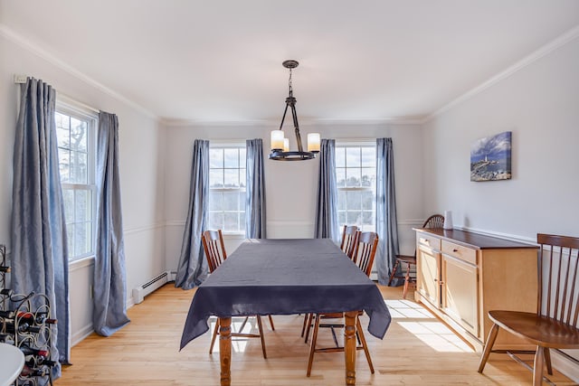 dining room featuring an inviting chandelier, crown molding, light wood-type flooring, and baseboard heating