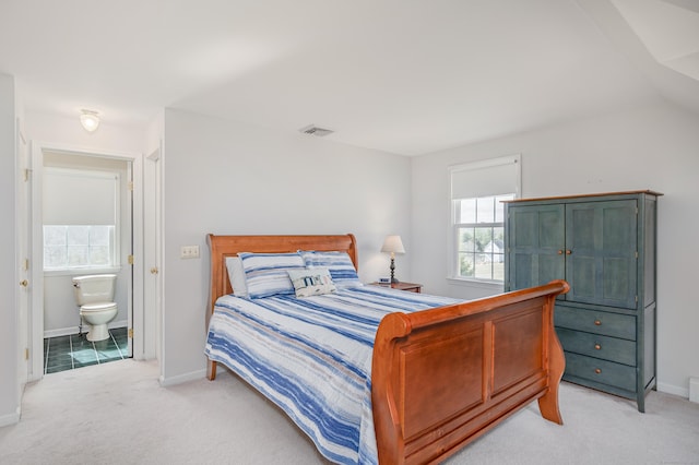 bedroom with visible vents, light carpet, baseboards, and connected bathroom