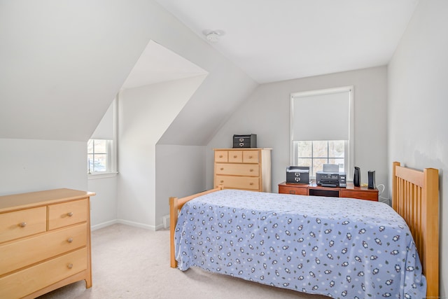 bedroom featuring lofted ceiling, light colored carpet, and baseboards