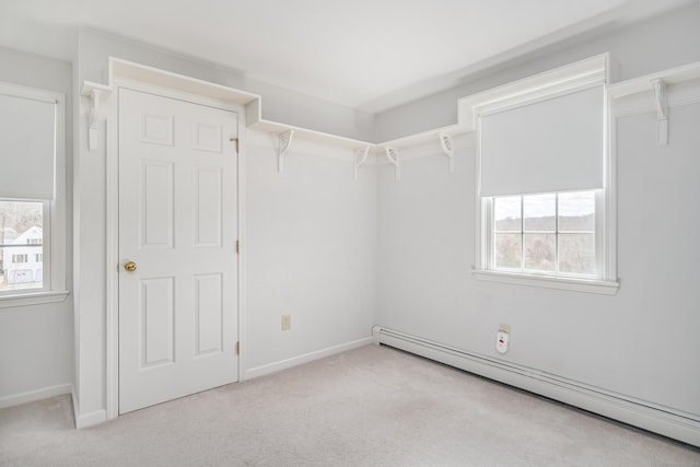 interior space featuring carpet flooring, a baseboard heating unit, and baseboards