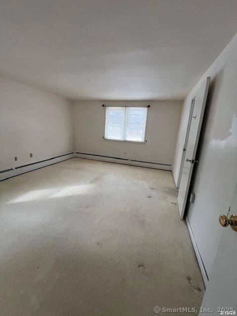 unfurnished room featuring a baseboard heating unit