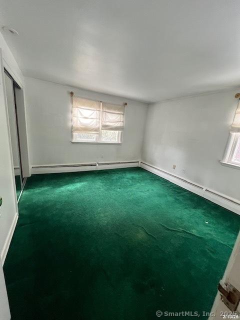 empty room featuring carpet and baseboards