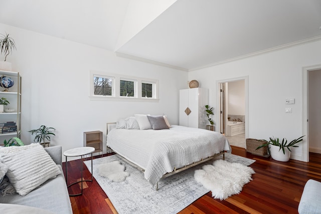 bedroom featuring wood finished floors, baseboards, ornamental molding, and ensuite bathroom