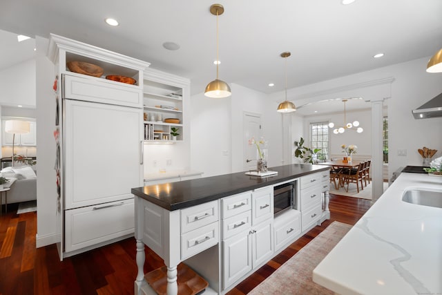 kitchen with open shelves, white cabinets, stainless steel microwave, and dark wood-style flooring