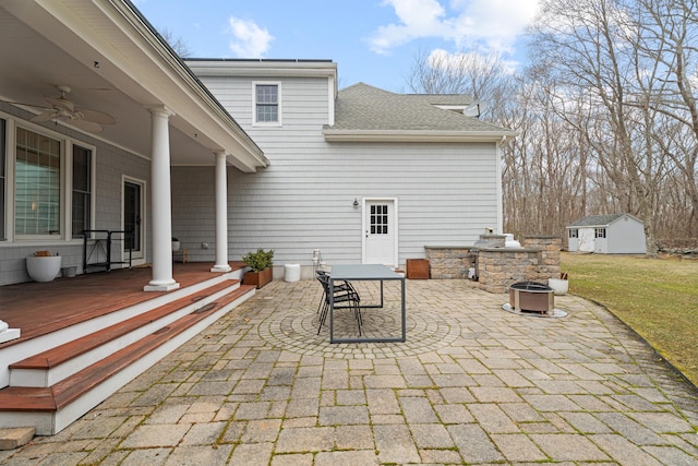view of patio with an outdoor structure, exterior kitchen, outdoor dining area, and ceiling fan