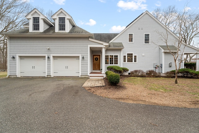 view of front of home featuring a shingled roof, driveway, and a garage