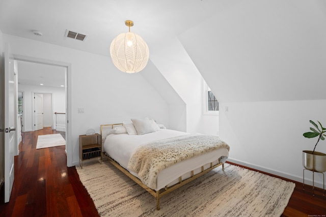 bedroom featuring baseboards, wood finished floors, and visible vents