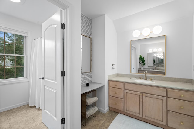 bathroom with baseboards, vanity, tile patterned flooring, and tasteful backsplash
