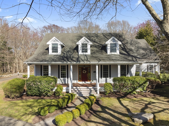 cape cod-style house with roof with shingles and a porch