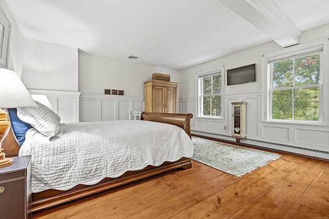 1 Hathaway Rd, East Lyme, CT 06333 - bedroom featuring a decorative wall, a wainscoted wall, wood finished floors, beam ceiling, and baseboard heating