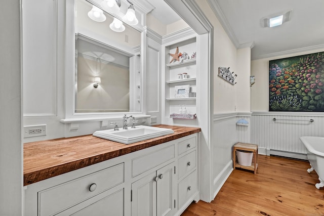 1 Hathaway Rd, East Lyme, CT 06333 - bathroom featuring ornamental molding, vanity, a freestanding tub, wainscoting, and wood finished floors