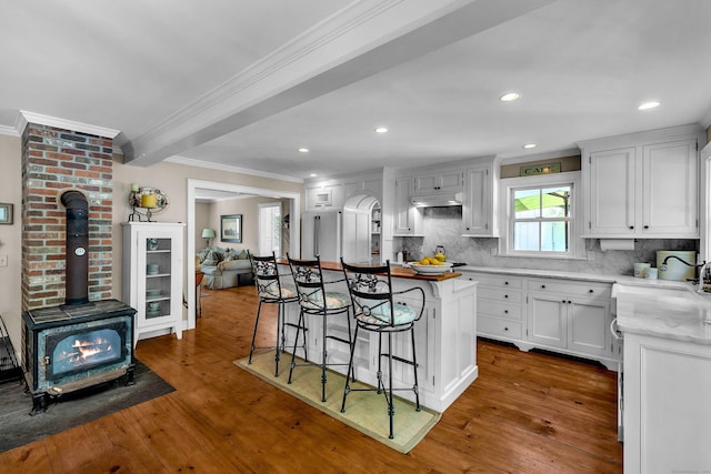 1 Hathaway Rd, East Lyme, CT 06333 - kitchen featuring crown molding, a breakfast bar area, hardwood / wood-style flooring, decorative backsplash, and recessed lighting