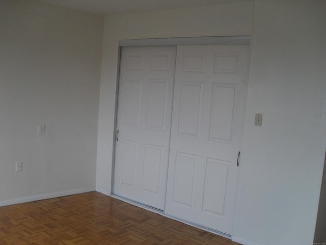 unfurnished bedroom with a closet and baseboards