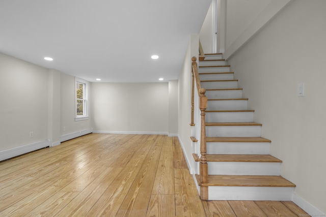 staircase with baseboards, a baseboard heating unit, wood-type flooring, and recessed lighting