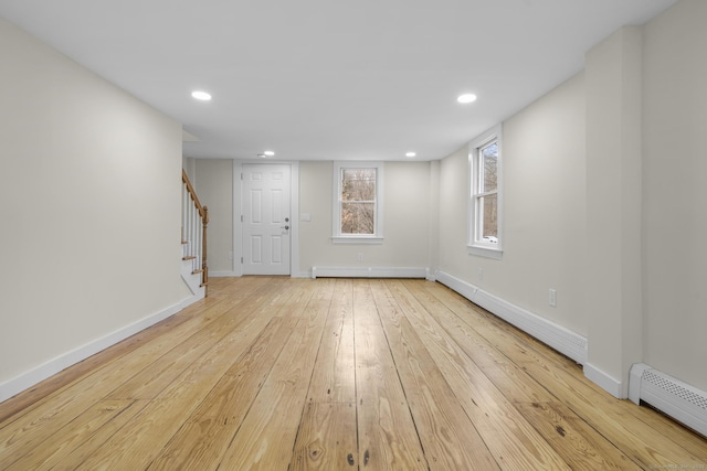 interior space featuring a baseboard radiator, hardwood / wood-style flooring, recessed lighting, baseboards, and stairs