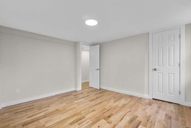 empty room with light wood-type flooring and baseboards