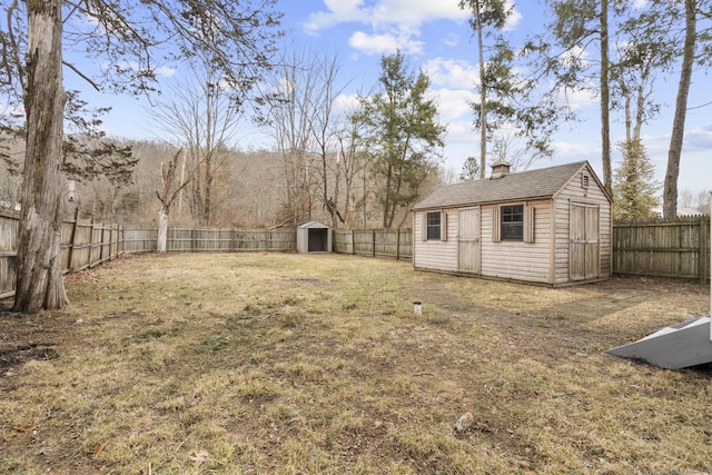 view of yard featuring a storage unit, an outdoor structure, and a fenced backyard