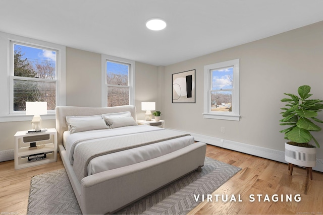 bedroom with baseboards, multiple windows, and light wood finished floors