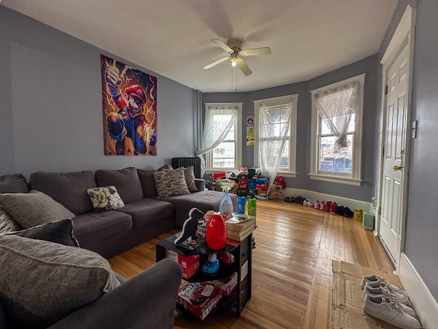 living area with hardwood / wood-style flooring and a ceiling fan