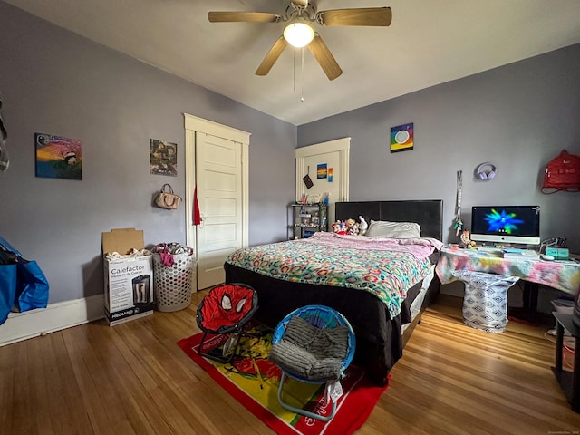 bedroom with baseboards, a ceiling fan, and wood finished floors