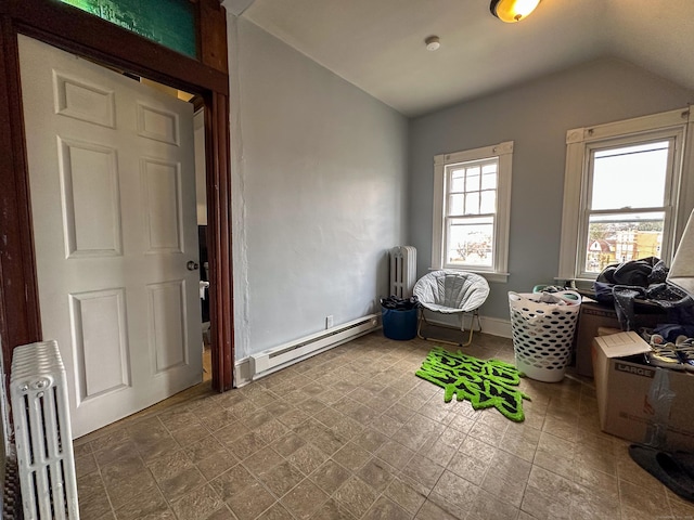 interior space featuring a baseboard heating unit, vaulted ceiling, and radiator