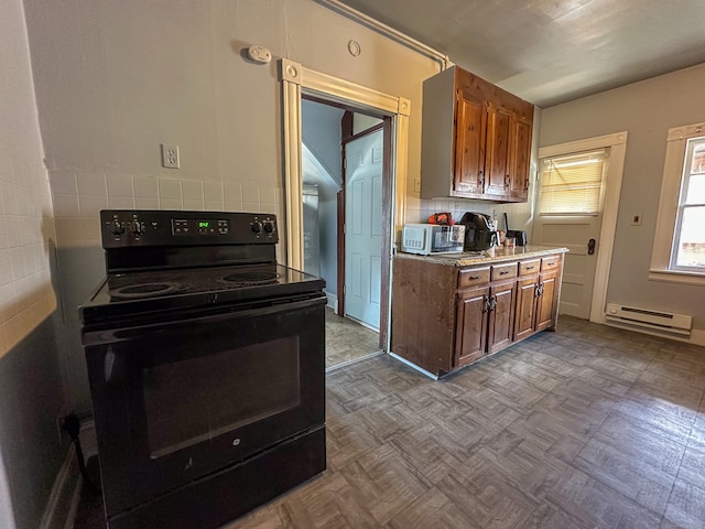 kitchen featuring brown cabinetry, light countertops, black range with electric cooktop, and a baseboard radiator