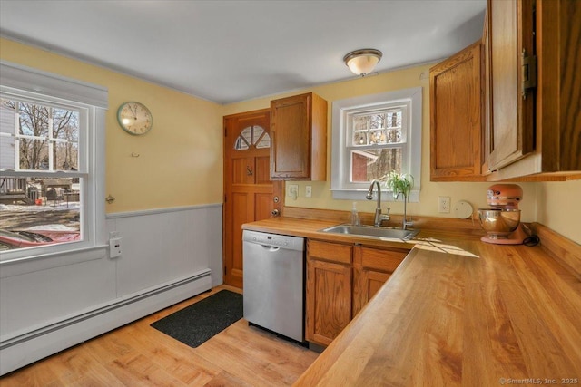 kitchen featuring wood counters, a sink, light wood-style floors, a baseboard heating unit, and stainless steel dishwasher