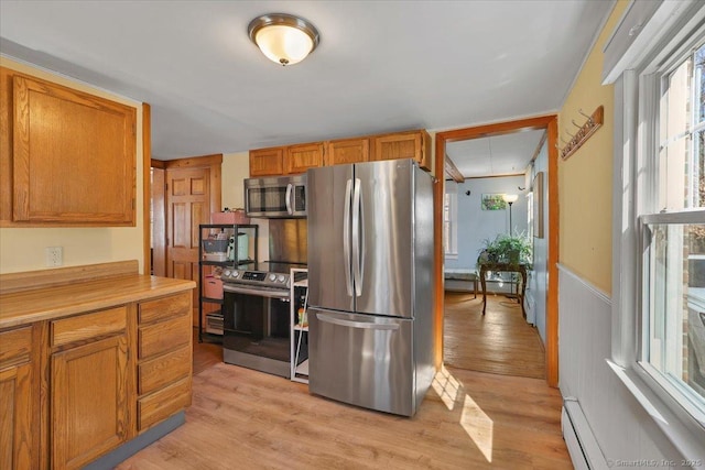 kitchen featuring light wood finished floors, light countertops, appliances with stainless steel finishes, and brown cabinetry