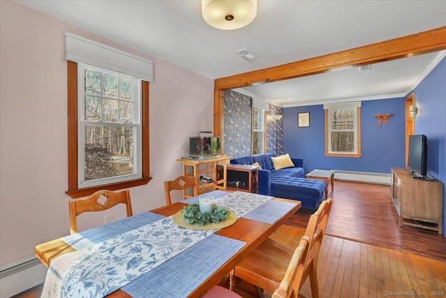 dining space with a baseboard heating unit, beamed ceiling, and hardwood / wood-style flooring