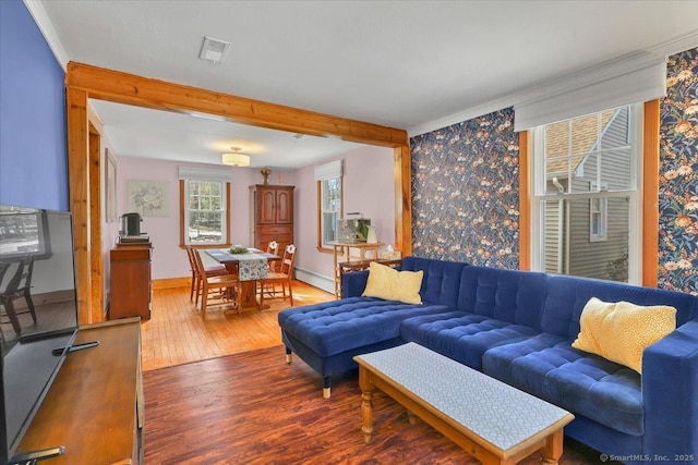 living area featuring a baseboard radiator, visible vents, baseboards, and wood finished floors