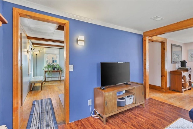 living room featuring wood-type flooring, visible vents, and baseboard heating