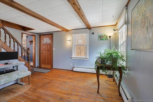 foyer featuring stairs, hardwood / wood-style flooring, a baseboard radiator, and beam ceiling