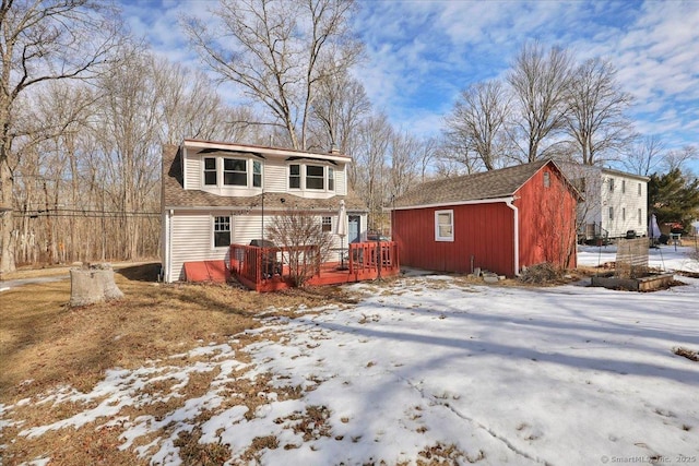 view of front of property featuring a shingled roof, an outdoor structure, and a deck