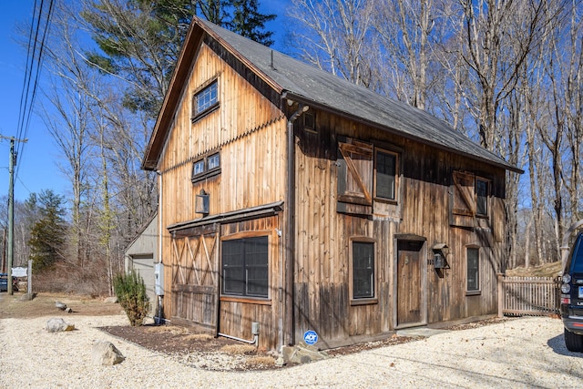 view of barn featuring fence