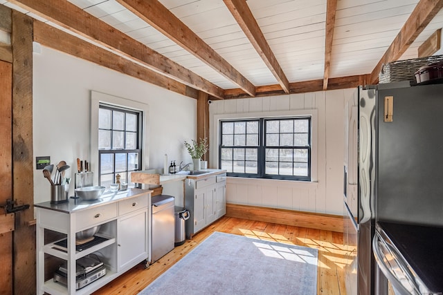 kitchen featuring beamed ceiling, a healthy amount of sunlight, and light wood-style floors