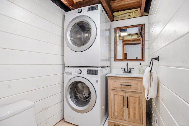 laundry area featuring a sink, stacked washer and clothes dryer, and laundry area