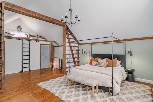 bedroom featuring lofted ceiling with beams, baseboards, an inviting chandelier, and wood finished floors