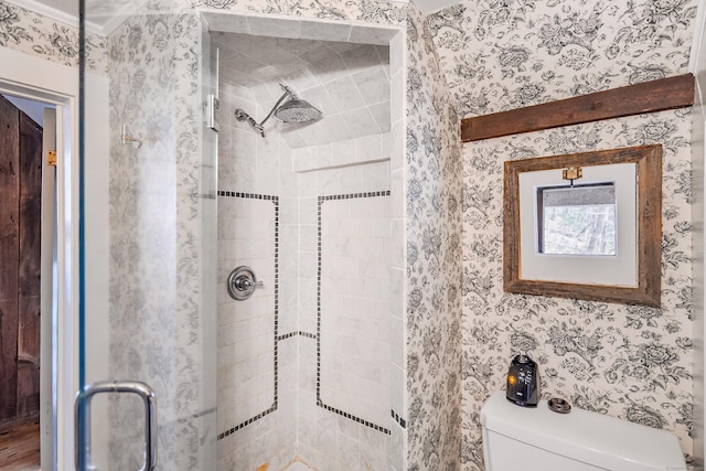 full bathroom with wallpapered walls, a shower stall, and toilet