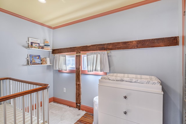 bedroom with baseboards, wood finished floors, and ornamental molding