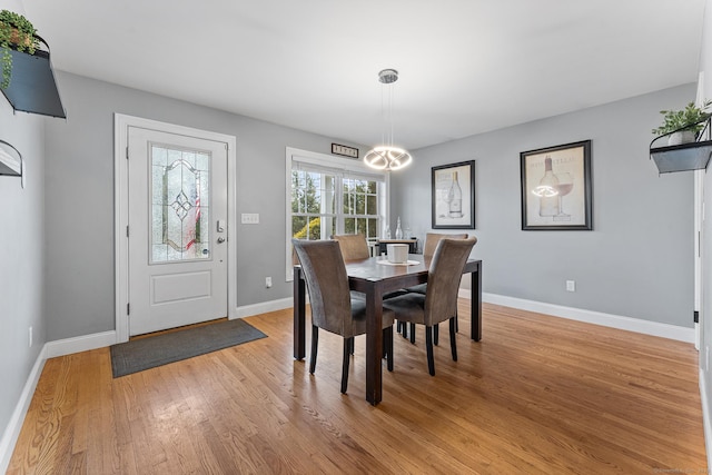 dining room featuring light wood finished floors and baseboards