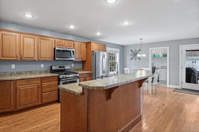 kitchen with brown cabinetry, recessed lighting, light wood-style floors, and stainless steel appliances