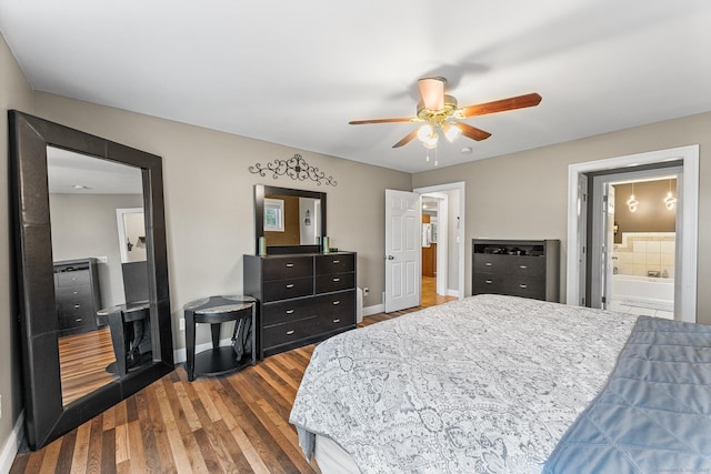 bedroom featuring connected bathroom, wood finished floors, baseboards, and ceiling fan