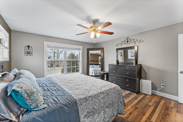 bedroom with dark wood-style floors, a ceiling fan, and baseboards