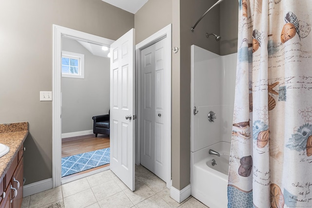 full bath with vanity, tile patterned floors, baseboards, and shower / bath combo with shower curtain