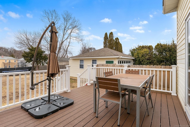 wooden deck with a trampoline, outdoor dining space, and fence