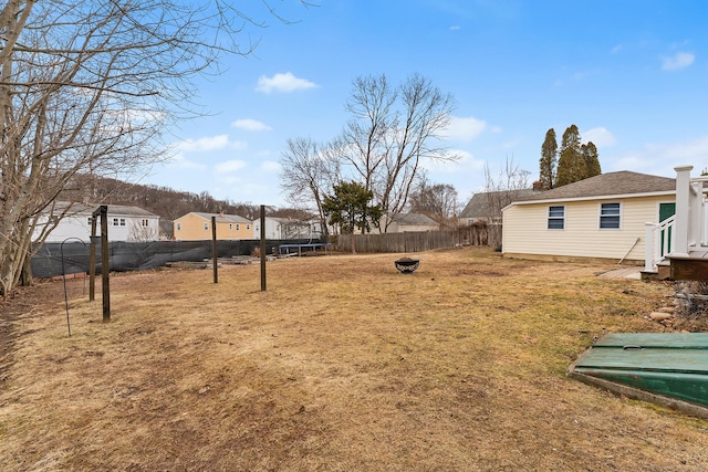 view of yard featuring a trampoline and a fenced backyard