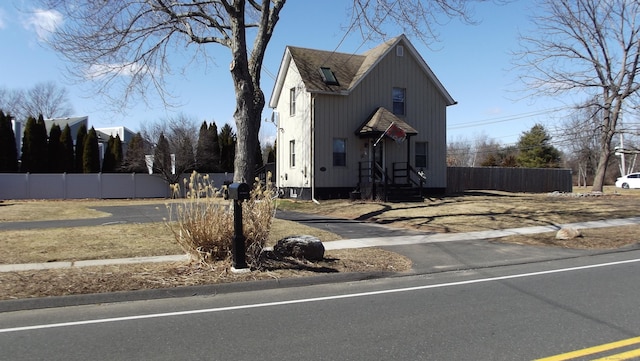 exterior space featuring a shingled roof, entry steps, and fence