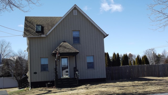 view of front of home featuring a shingled roof, entry steps, and fence