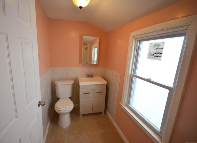 bathroom with tile patterned floors, toilet, a healthy amount of sunlight, and vaulted ceiling