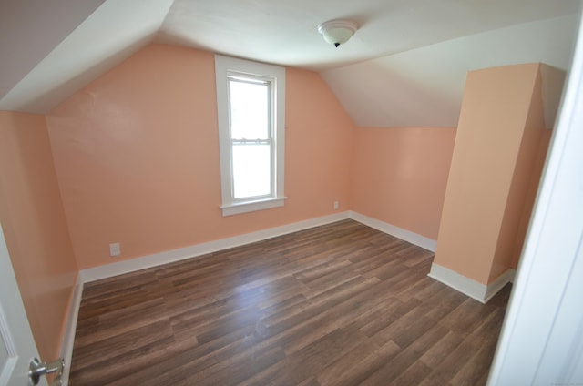 bonus room featuring dark wood finished floors, lofted ceiling, and baseboards